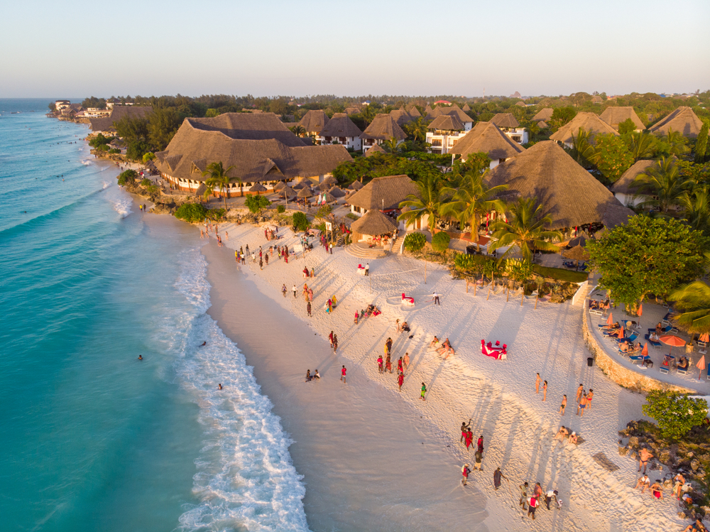 Aerial view of people walking on a Zanzibar beach at sunset